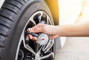 Checking car tyre pressure in summer